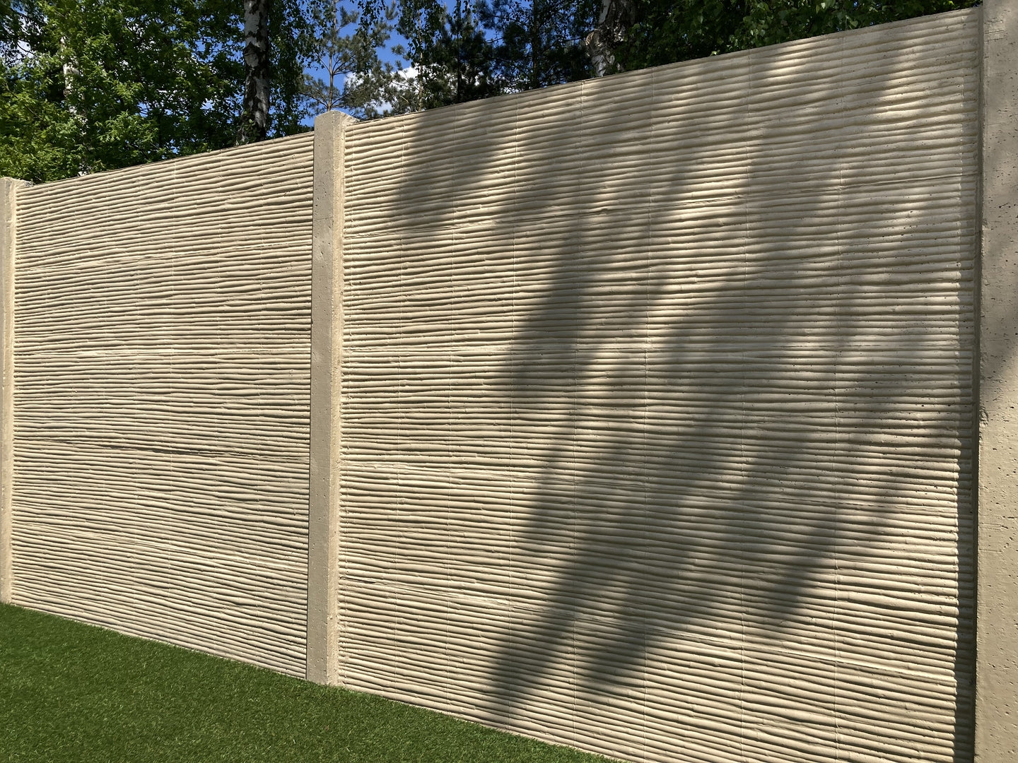 Betonzaun in Bambus Optik auf grüner Wiese